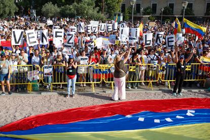Los ciudadanos gritan consignas, durante la concentración convocada bajo el lema 'Alcemos la voz por el cambio en Venezuela' este domingo en la plaza de Colón, en Madrid.