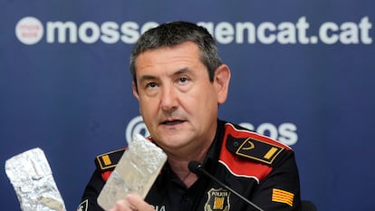 El inspector jefe de los Mossos d'Esquadra Lisard Hidalgo muestra en rueda de prensa dos teléfonos incautados envueltos en papel de plata para inhibir la geolocalización.