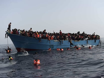 Migrantes en alta mar esperan a ser rescatados en una operación coordinada por la Marina italiana.