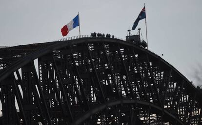 La bandera tricolor francesa al lado de la bandera nacional australiana sobre el puente de Sydney, en apoyo a las víctimas.