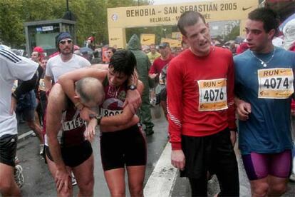 Varios atletas llegan exhaustos a la meta de la Behobia-San Sebastián, situada en el Boulevard donostiarra.