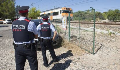 Dos Mossos d&acute;Esquadra frente al tren averiado entre L&#039;Ametlla de Mar y L&#039;Hospitalet de l&#039;Infant.