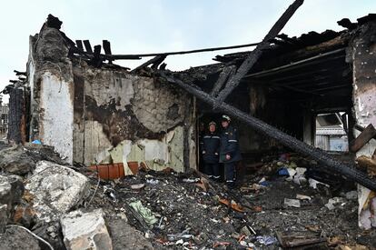 Dos bomberos inspeccionan los restos de una vivienda destruida por un ataque ruso en Zaporiyia este domingo.