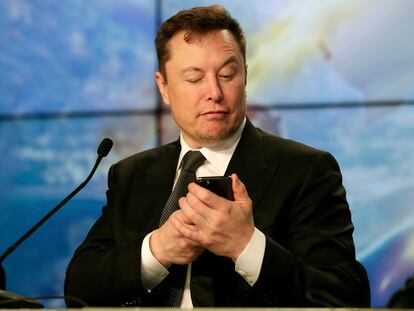 El multimillonario Elon Musk bromea usando su celular durante una conferencia de prensa, en 2020.