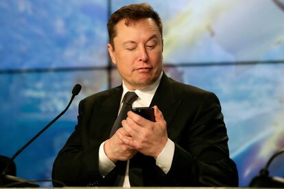 El multimillonario Elon Musk bromea usando su celular durante una conferencia de prensa, en 2020.