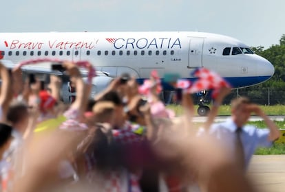 Un grupo de aficionados vitorea tras el aterrizaje del Airbus 319 con la selección croata de fútbol a bordo en el aeropuerto de Zagreb.
