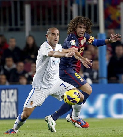 Puyol y Aranda pelean por el balón.