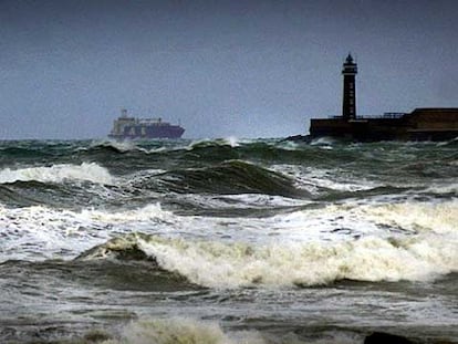 Un barco enfila la bocana del puerto de Valencia en medio de un gran oleaje.