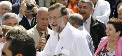 El presidente del Gobierno, Mariano Rajoy (c), durante su visita hoy a la localidad lucense de Portomarín, donde ha sido nombrado Caballero de la Real Orden Serenísima de la Alquitara.