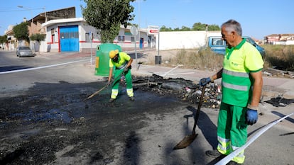 Operarios limpian los restos quemados de un contenedor en Torre Pacheco (Murcia), este domingo.