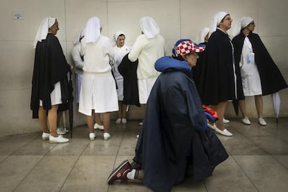 Una peregrina reza junto a un grupo de monjas en el santuario de Nuestra Señora de Fátima.