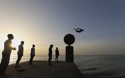 Atardecer en la costa de Bengasi, Libia, donde unos jóvenes se entretienen lanzándose a las aguas del mar Mediterráneo. 4 de abril de 2014.