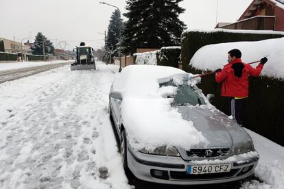 Um homem tira a neve que cobriu seu carro, neste sábado, em Tarragona.