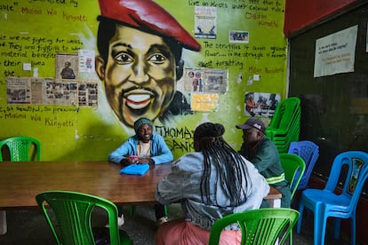 Tres jóvenes charlan en el Centro de Justicia Social de Mathare, la segunda barriada marginal más grande de Nairobi, el pasado 10 de junio. Preside la sala una pintura del revolucionario marxista y panafricanista Thomas Sankara, presidente de Burkina Faso desde 1983 hasta su asesinato en 1987.