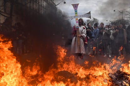 Un manifestante disfrazado de Jesús sujeta una cruz en la que se lee "Amor, no guerra", durante las protestas de este martes en París.