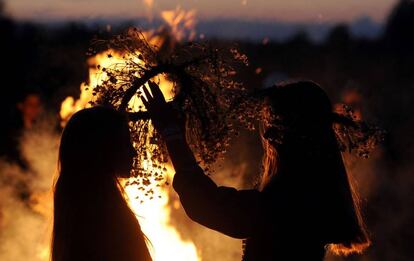 Dos chicas se colocan coronas tradicionales durante la noche de Iván Kupala, que celebra el solsticio de invierno, en la ciudad de Turov (Bielorrusia).