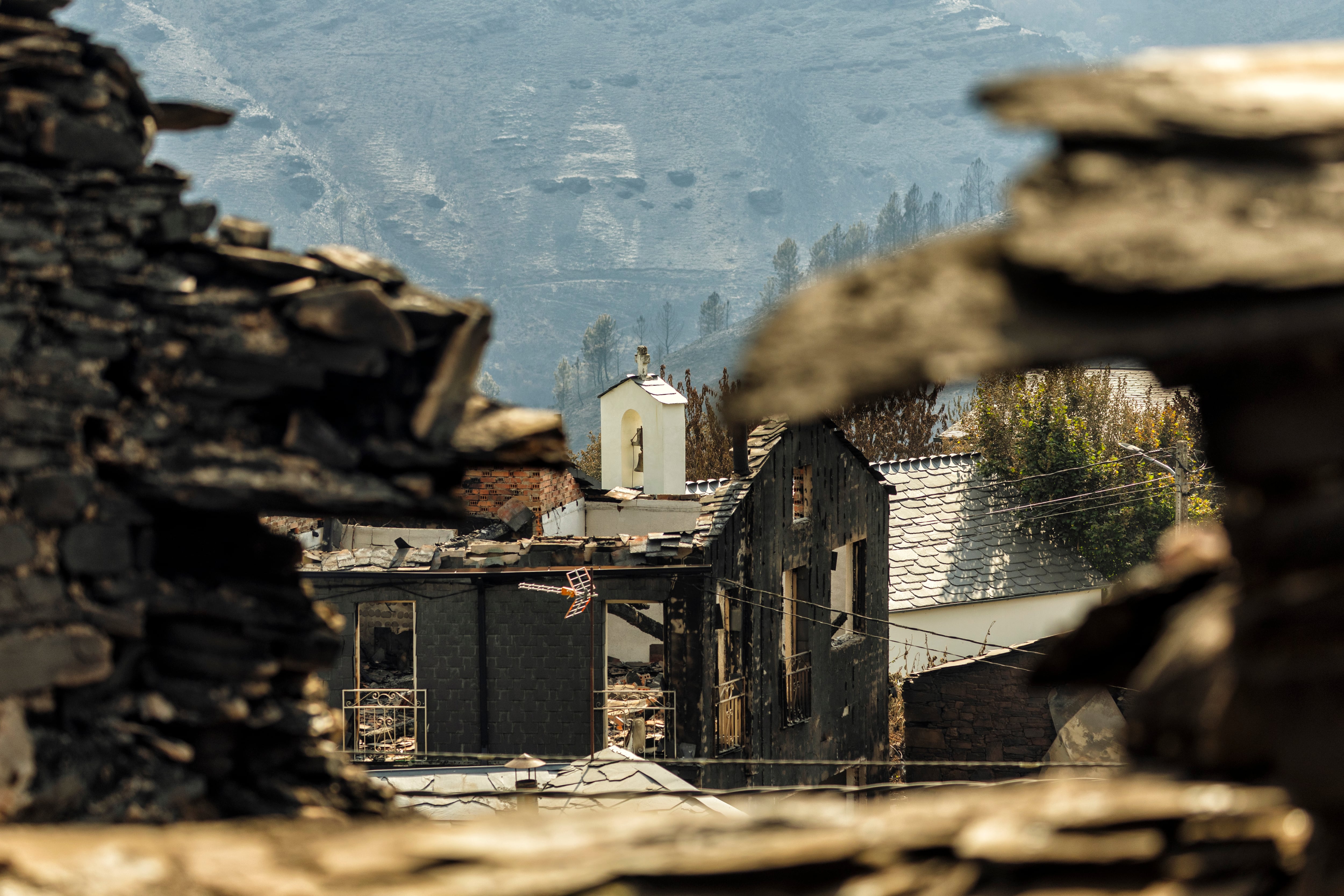 Imagen de la iglesia de San Vicente de Leira, en Ourense, entre las viviendas destrozadas, este agosto.