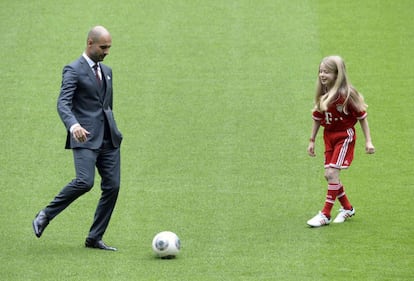 El nuevo técnico del conjunto alemán toca balón en el césped del estadio junto a una joven aficionada.