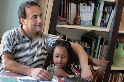 El alcalde de Riace, Domenico Lucano, con una niña procedente de Etiopía.