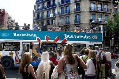 Un grupo de visitantes recorre Barcelona en el autobús turístico.