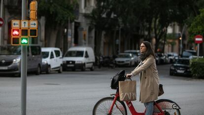 Una mujer espera al verde en el semáforo del carril bici de Barcelona.