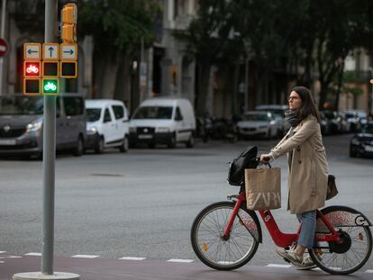 Una mujer espera al verde en el semáforo del carril bici de Barcelona.
