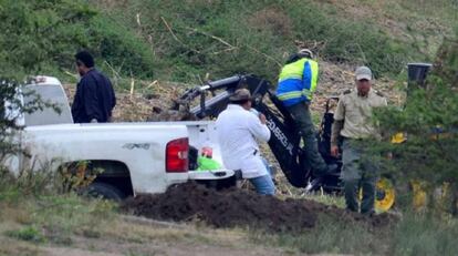 Forenses mexicanos inspeccionan una fosa en 2013.