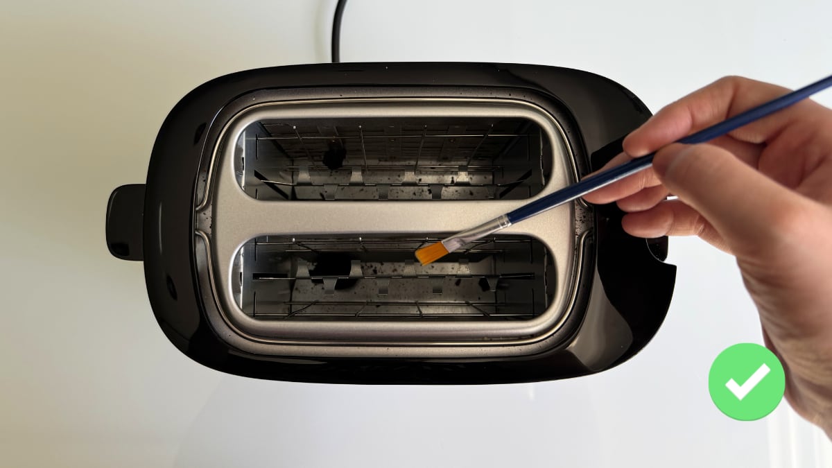Prueba de limpieza de la tostadora Philips Daily Collection con un pincel.