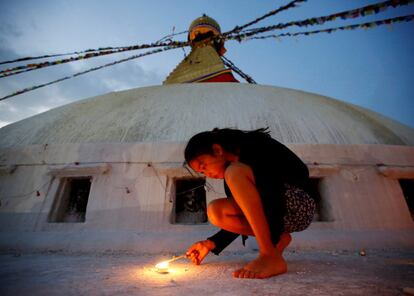 Una niña enciende una vela en el aniversario del terremoto de Nepal en 2015, en la estupa de Boudhanath, localidad de Katmandú (Nepal).