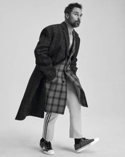 El actor californiano avanza con abrigo superpuesto sobre abrigo y pantalones, todo, Calvin Klein 205W39NYC, y zapatillas Golden Goose.