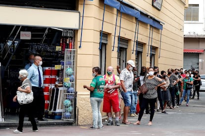 Clientes fazem fila para entrar em loja do centro de São Paulo após abertura do comércio de rua ser autorizada em determinados horários.