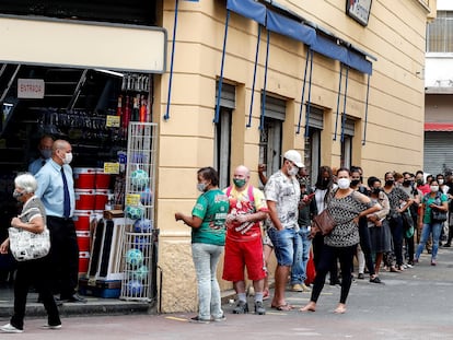 Clientes fazem fila para entrar em loja do centro de São Paulo após abertura do comércio de rua ser autorizada em determinados horários.
