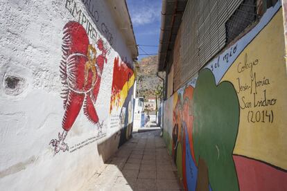 Vista de un callejón decorado con varios murales dedicados a Miguel Hernández. A la izquierda, una representación de la portada de la revista literaria 'El Gallo Crisis' en la que colaboraba el poeta. La publicación fue fundada y dirigida por Ramón Sijé, mejor amigo de Hernández, a quien dedicó 'Elegía', uno de sus poemas más célebres, cuando falleció a los 22 años.