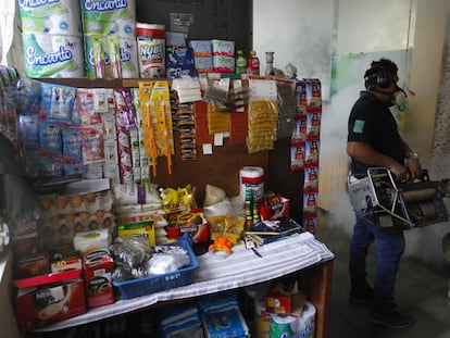 Un empleado del Ministerio de Salud de El Salvador fumiga una casa.