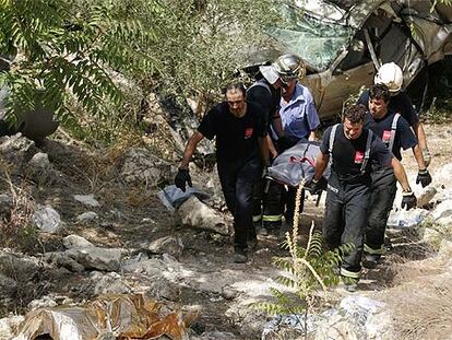 Bomberos de la Comunidad de Madrid transportan el cuerpo de una de las víctimas mortales del accidente de ayer en la A-3.