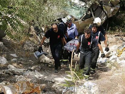 Bomberos de la Comunidad de Madrid transportan el cuerpo de una de las víctimas mortales del accidente de ayer en la A-3.