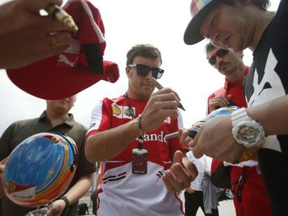 Alonso firma cascos de Renault, en Sepang.