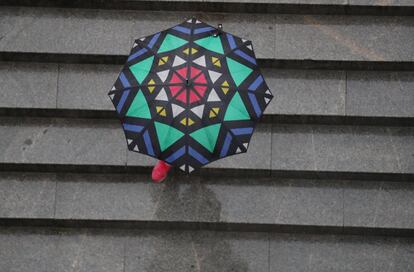 Una mujer se protege de la lluvia con un paraguas este viernes en Bilbao. Todo el país, salvo Canarias, está hoy en alerta por la borrasca Álex que dejará vientos de hasta 100 kilómetros por hora y lluvias que acumularán hasta 15 litros por metro cuadrado en una hora en zonas del norte, además de grandes olas en el litoral, de hasta seis metros en el Cantábrico.