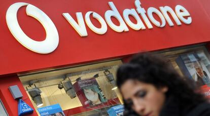 Un transe&uacute;nte camina frente a una tienda de Vodafone. EFE/Archivo