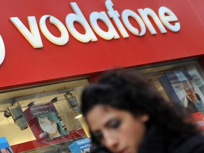 Un transe&uacute;nte camina frente a una tienda de Vodafone. EFE/Archivo