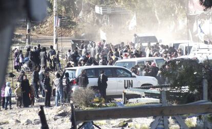 Los civiles se reúnen antes de ser evacuados de la ciudad siria de Homs. Miembros de la Luna Media Roja y el personal de las Naciones Unidas.