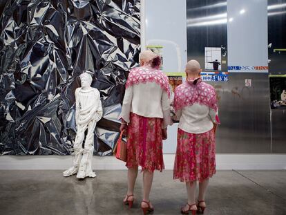Dos visitantes contemplan la escultura <i>Adam,</i> del artista polaco Pawel Althamer, en el <i>stand</i> de la galería berlinesa Neugerriemschneider.