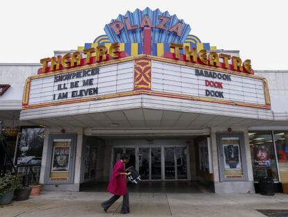 Mulher diante do cinema em Atlanta que anunciou que projetará o filme.