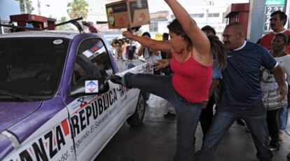 Un grupo de salvadoreños ataca un coche de Arena durante la pasada campaña electoral de marzo.