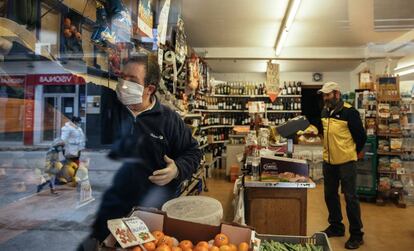 Un comerciante atiende a un cliente en Huesca, en marzo. 