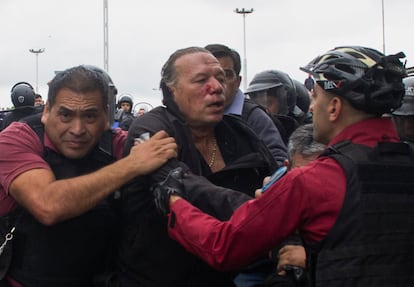 El ministro de Seguridad de la provincia de Buenos Aires, Sergio Berni, es protegido por policías tras ser agredido por un grupo de choferes de buses, el 3 de abril de 2023.