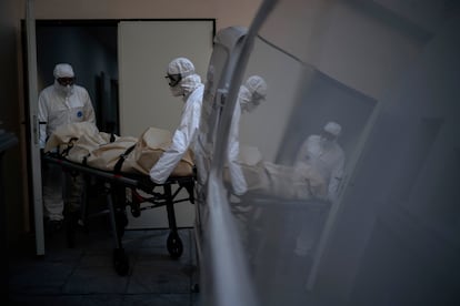 Two funeral workers in Barcelona transport the body of a Covid-19 victim in November.