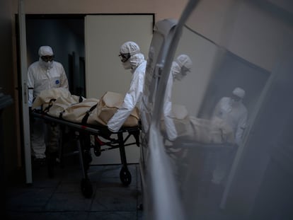 Dos trabajadores de una funeraria recogen un cadáver de una víctima de covid en una residencia en Barcelona, el 19 de noviembre.