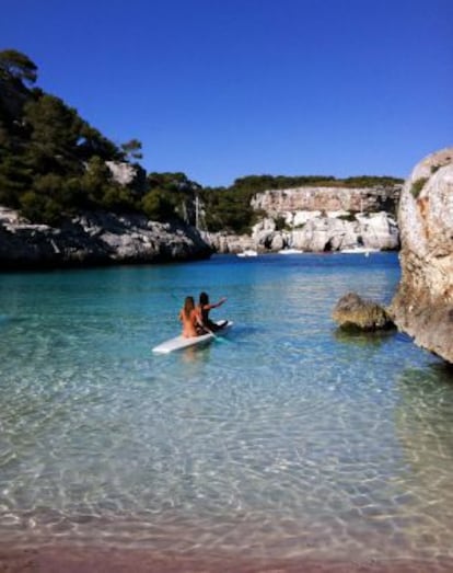 Dos chicas navegando en la cala menorquina de la Macarelleta.