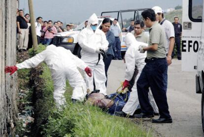 Un equipo forense inspecciona un cadáver hallado ayer en una zona residencial de Cuernavaca.